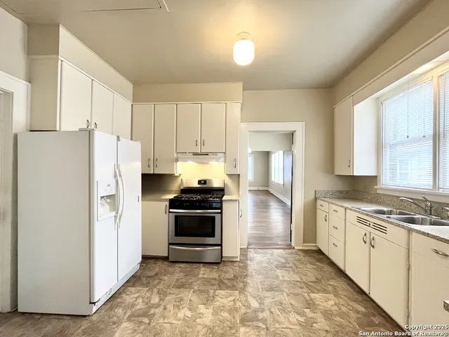 a kitchen with stainless steel appliances a refrigerator sink and stove