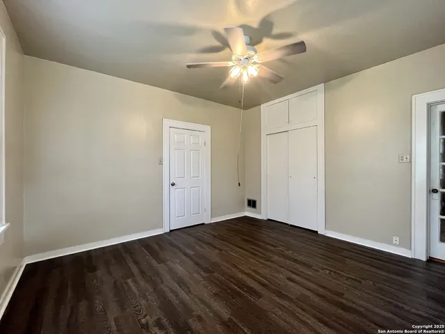 a view of an empty room with wooden floor