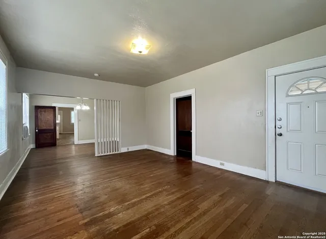 a view of an empty room with wooden floor