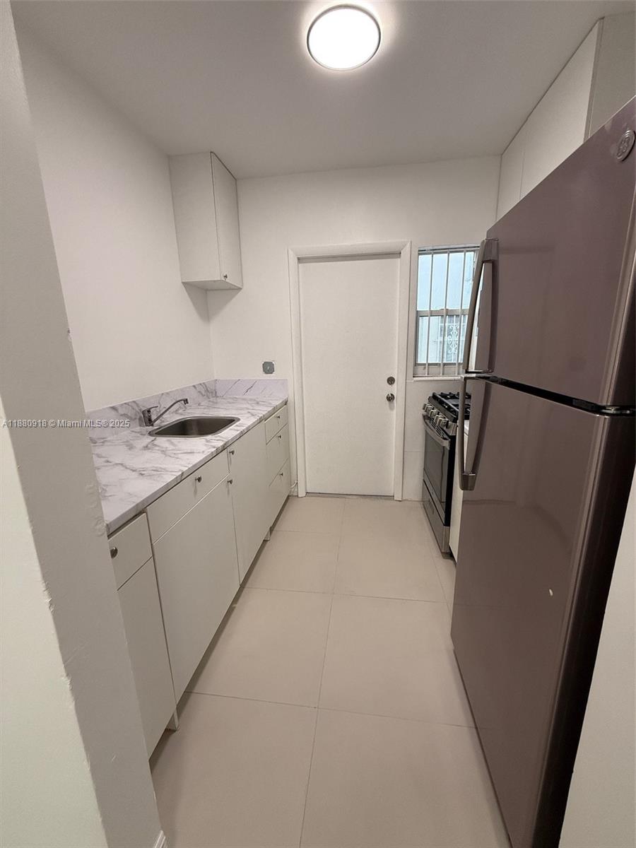 542 Euclid Avenue, Unit 4 Miami Beach, FL 33139 - Photo 2 of 10 a kitchen with a refrigerator a stove a washer and dryer