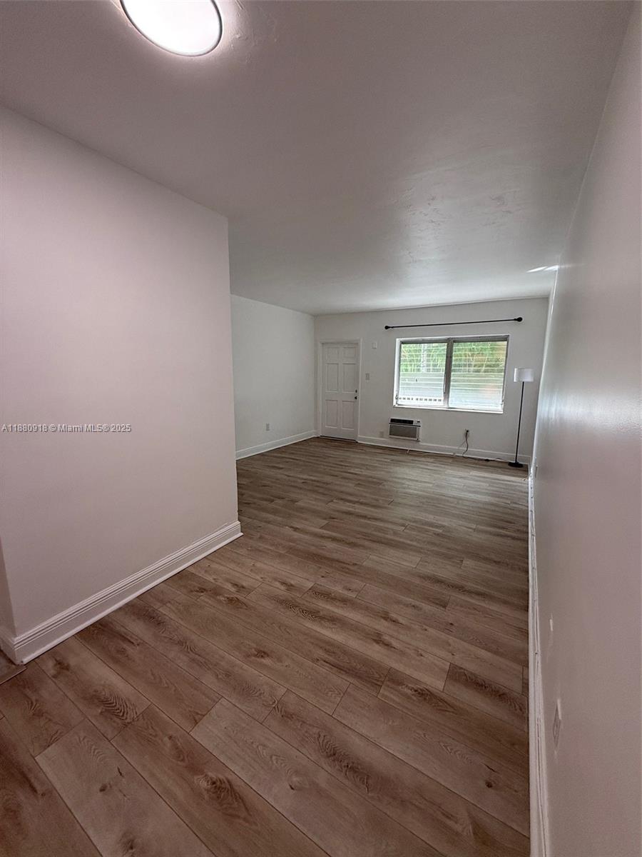 542 Euclid Avenue, Unit 4 Miami Beach, FL 33139 - Photo 4 of 10 an empty room with wooden floor and windows