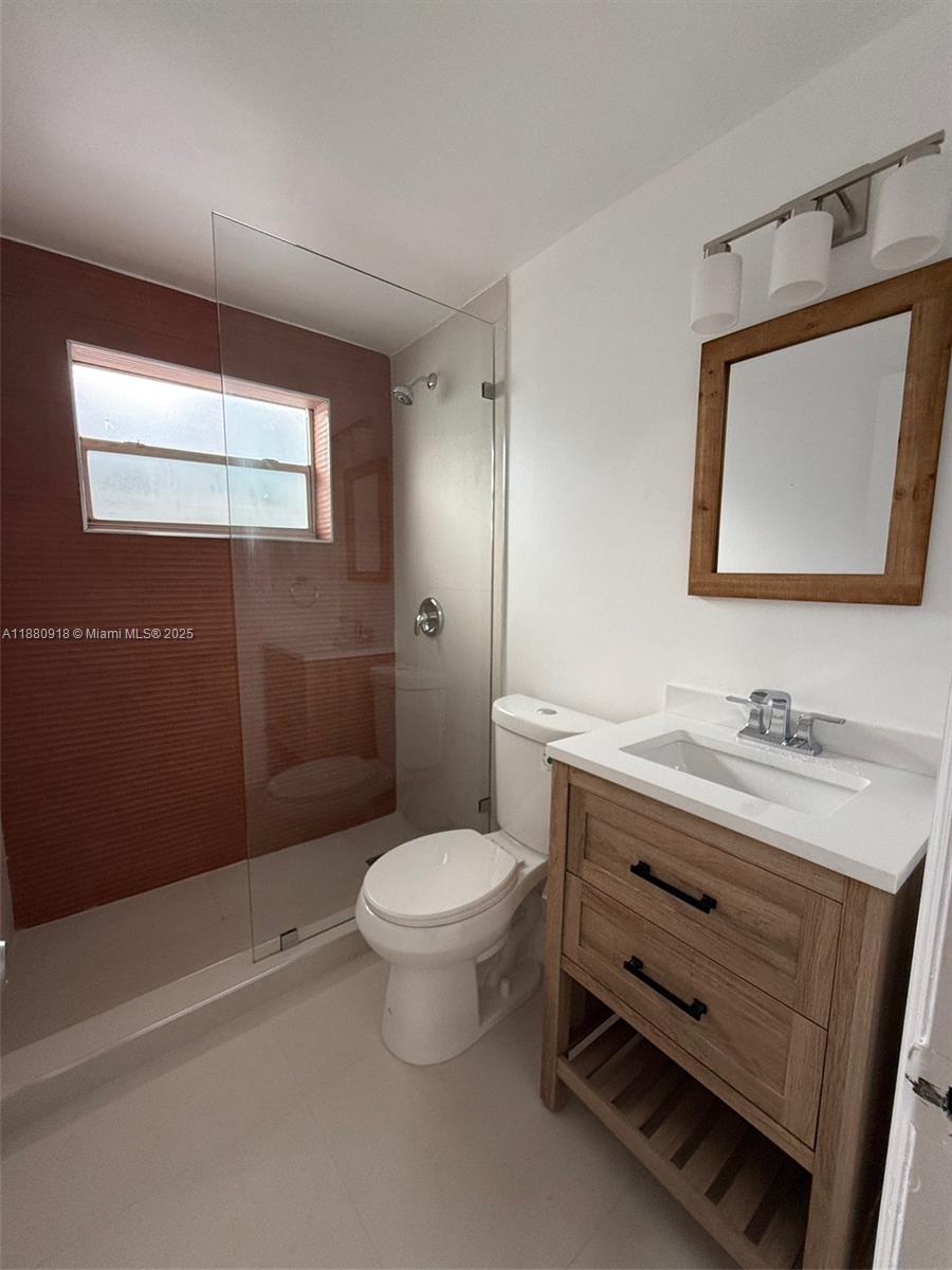 542 Euclid Avenue, Unit 4 Miami Beach, FL 33139 - Photo 6 of 10 a bathroom with a toilet sink and mirror