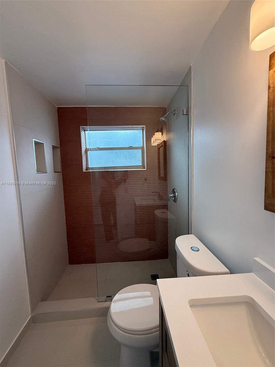 542 Euclid Avenue, Unit 4 Miami Beach, FL 33139 - Photo 7 of 10 a white toilet sitting next to a bathroom sink and vanity