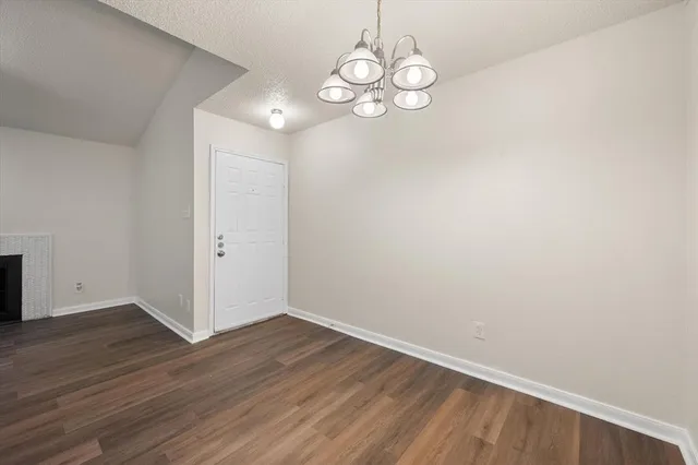 a view of a room with wooden floor and white walls