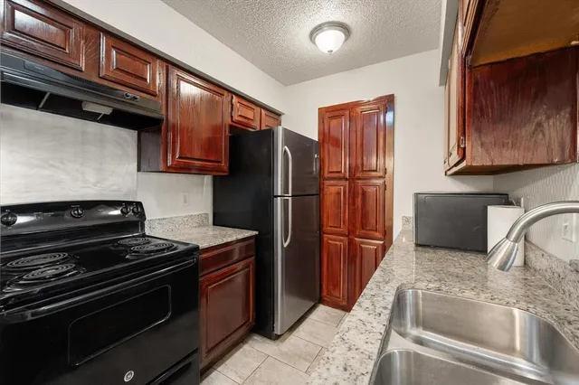 a kitchen with granite countertop stainless steel appliances and wooden cabinets