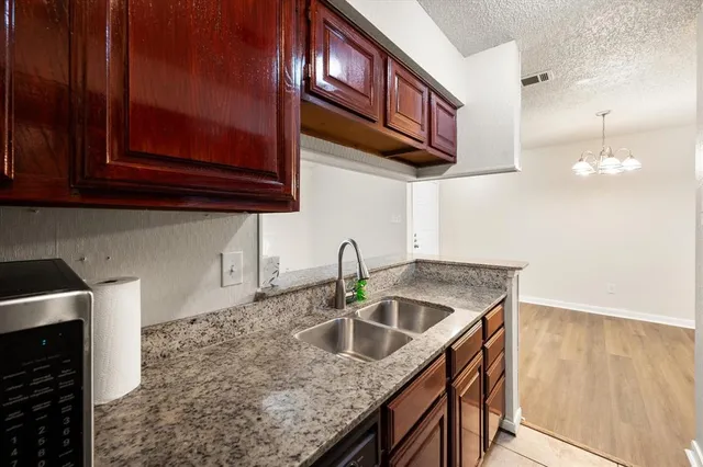 a kitchen with stainless steel appliances granite countertop a sink a stove and a microwave oven