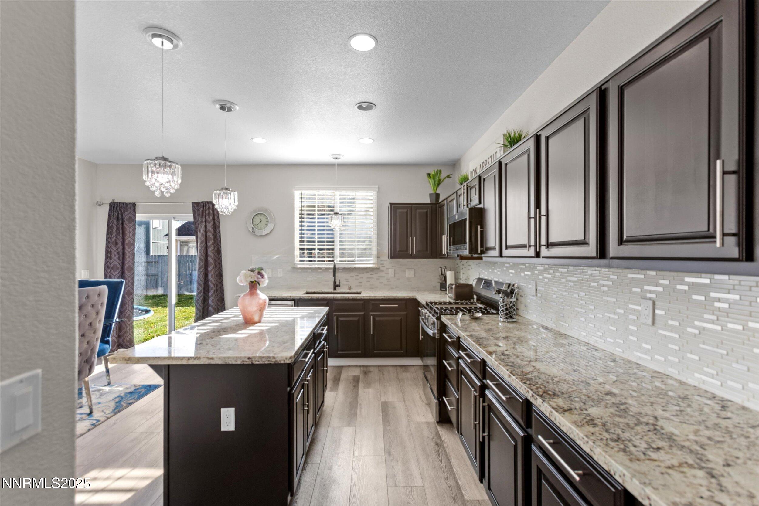 8922 Sorcha Street Reno, NV 89506 - Photo 11 of 47 a kitchen with kitchen island granite countertop a sink stove and cabinets