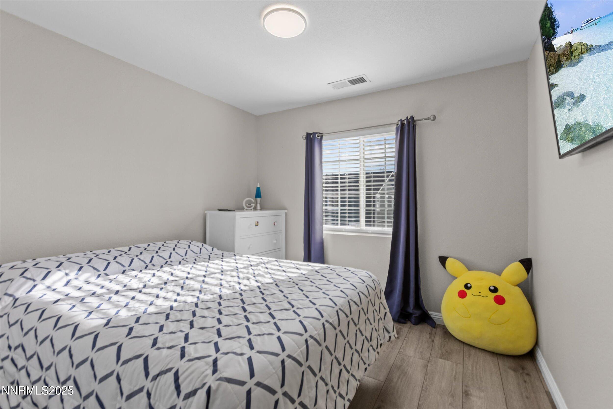 8922 Sorcha Street Reno, NV 89506 - Photo 34 of 47 a bedroom with a bed and wooden floor