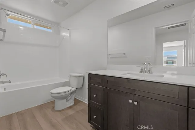 a bathroom with a sink a toilet a mirror and bathtub