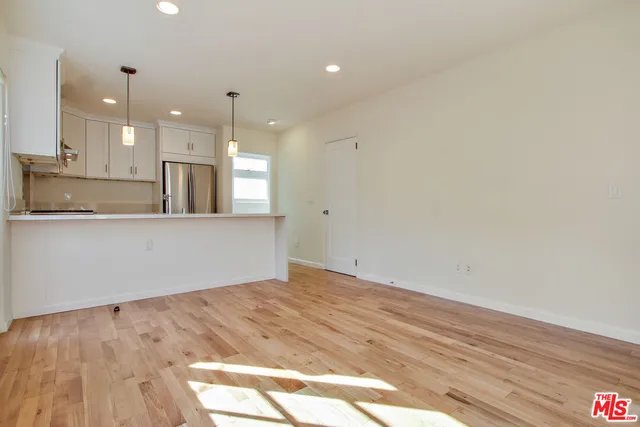 a kitchen that has a sink a stove and a table with wooden floor