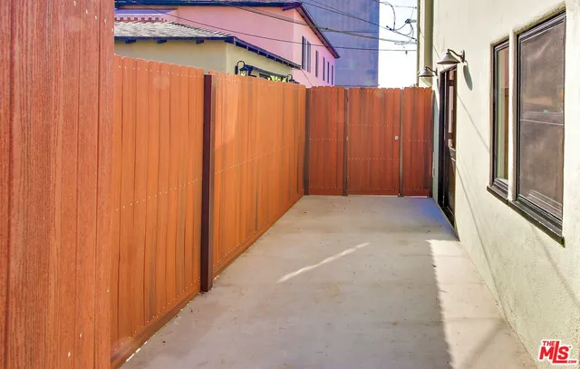 a backyard of a house with large trees and barbeque oven