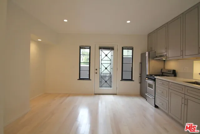 a kitchen with granite countertop white cabinets and stainless steel appliances