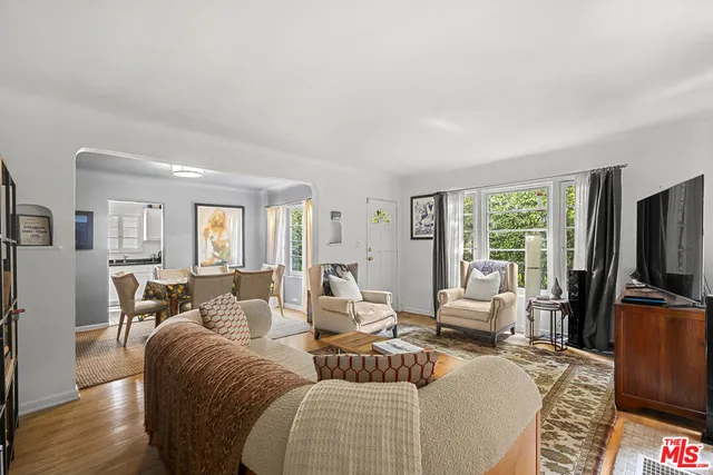 a living room with furniture flat screen tv and wooden floor