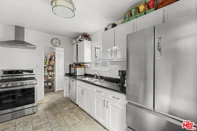 a kitchen with stainless steel appliances a stove a refrigerator and cabinets