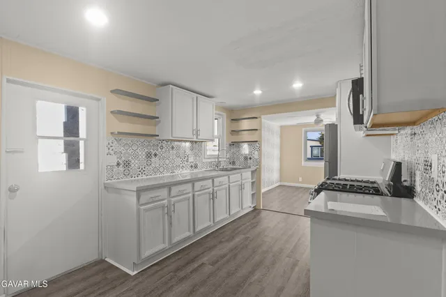 a kitchen with stainless steel appliances a refrigerator stove and microwave