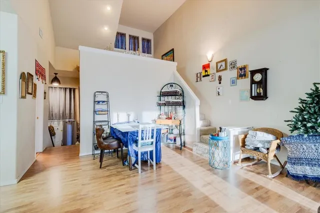 a living room with furniture and a dining table with wooden floor