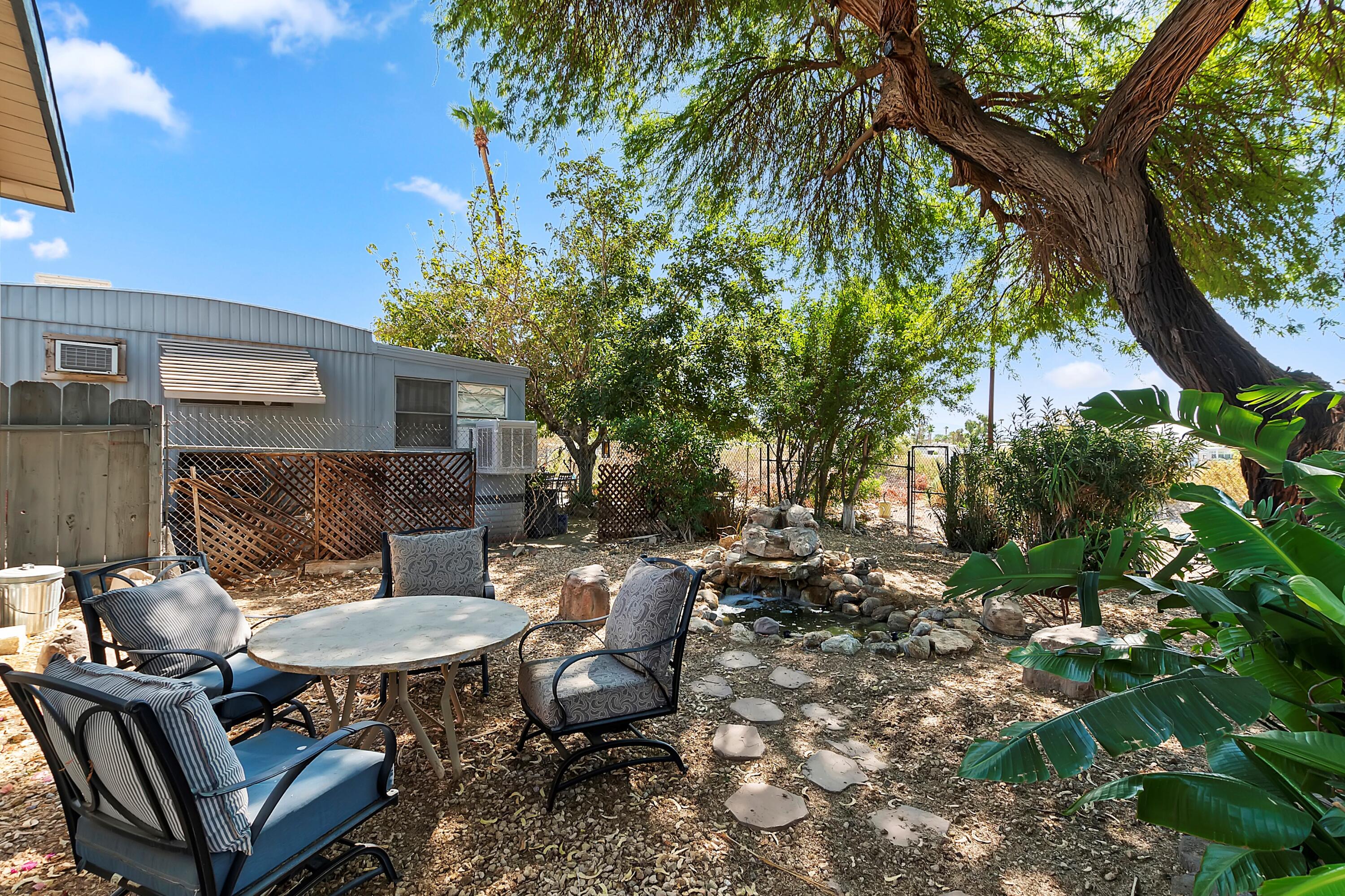 74711 Dillon Road, Unit 331 Desert Hot Springs, CA 92241 - Photo 29 of 53 a backyard of a house with table and chairs