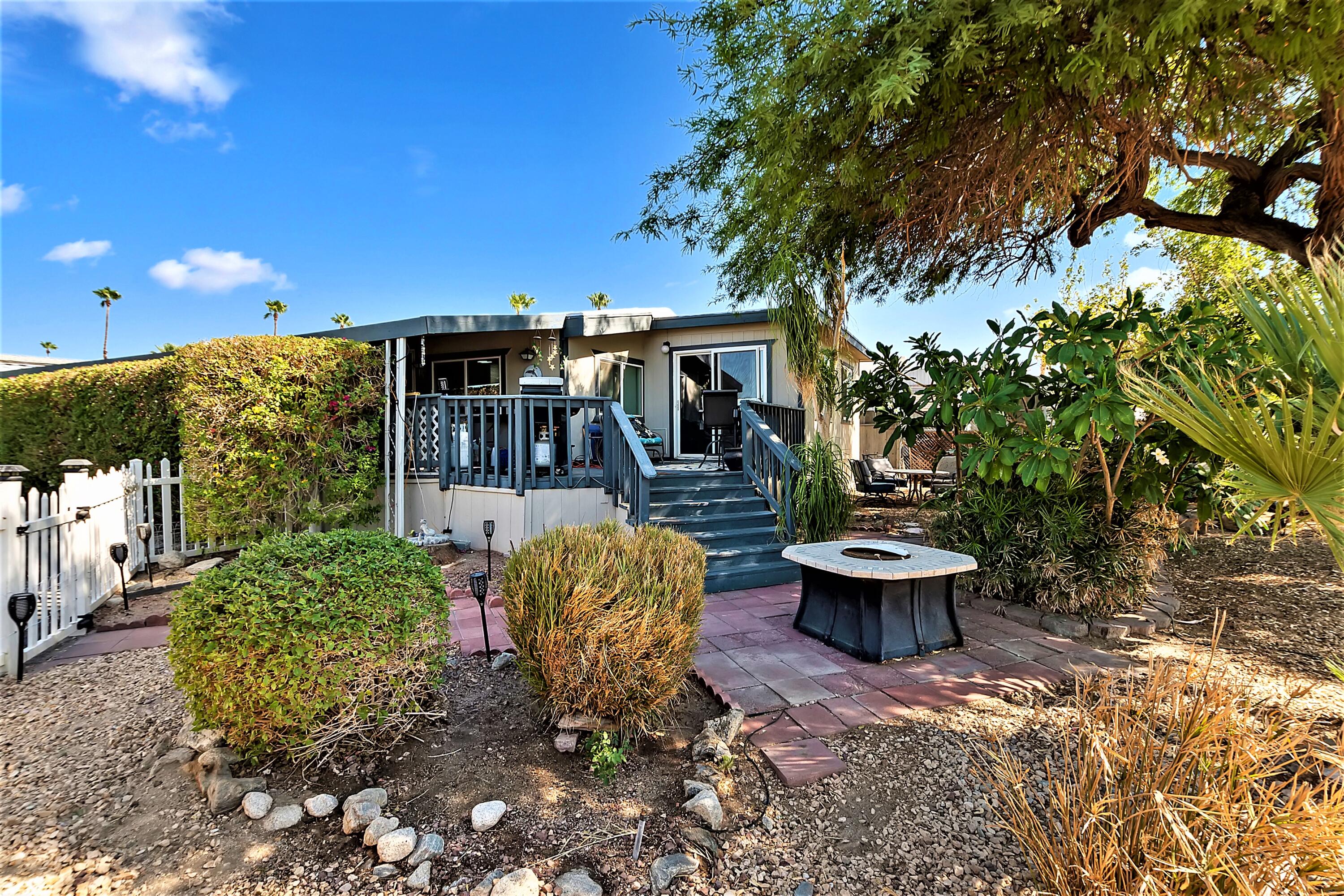 74711 Dillon Road, Unit 331 Desert Hot Springs, CA 92241 - Photo 6 of 53 a view of a patio with table and chairs potted plants and large tree