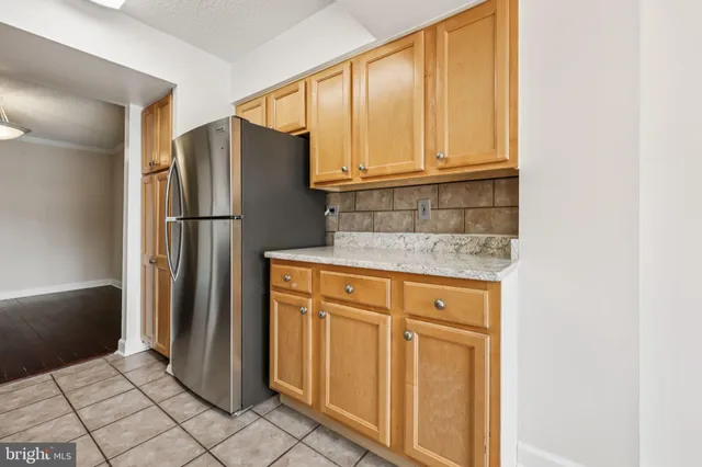 a view of a refrigerator in kitchen and a window