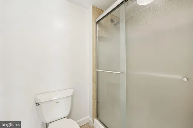a bathroom with a bathtub shower sink vanity mirror and toilet