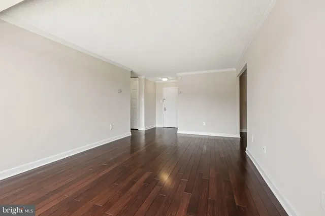 a view of an empty room with wooden floor