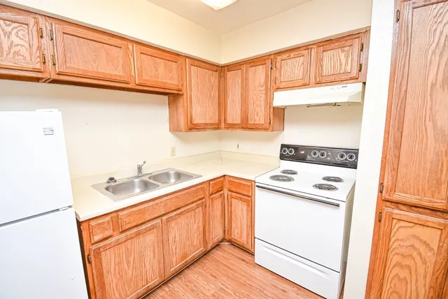 a kitchen with a sink a stove and cabinets