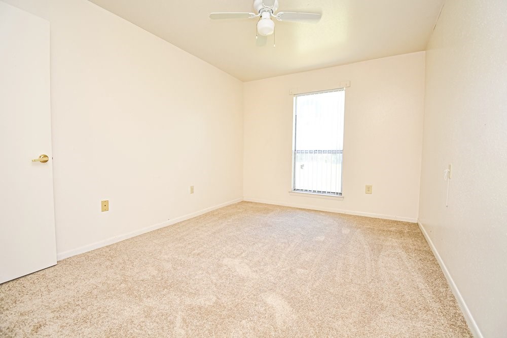 576 Ellen Powell Hempstead, TX 77445 - Photo 10 of 13 an empty room with a chandelier fan and windows