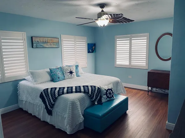 a bed sitting in a bedroom next to a window with a chandelier