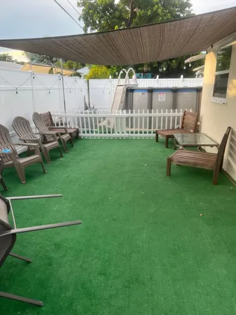 a view of a patio with table and chairs with wooden fence