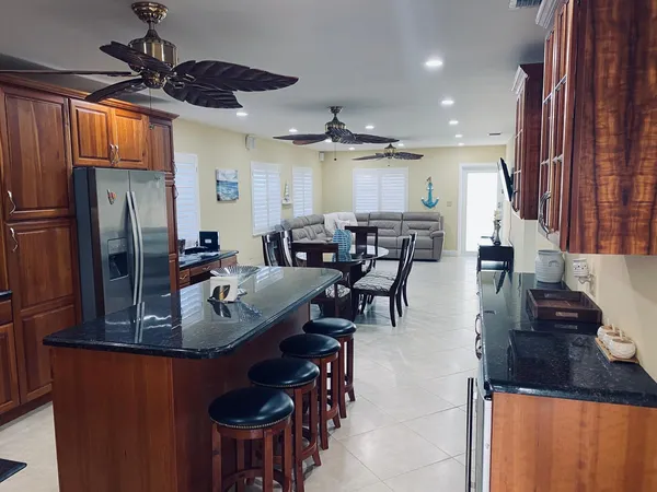 a kitchen with stainless steel appliances granite countertop a sink a stove and a refrigerator