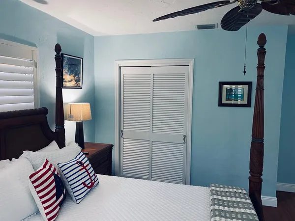 a bedroom with a bed and a lamp on a dresser