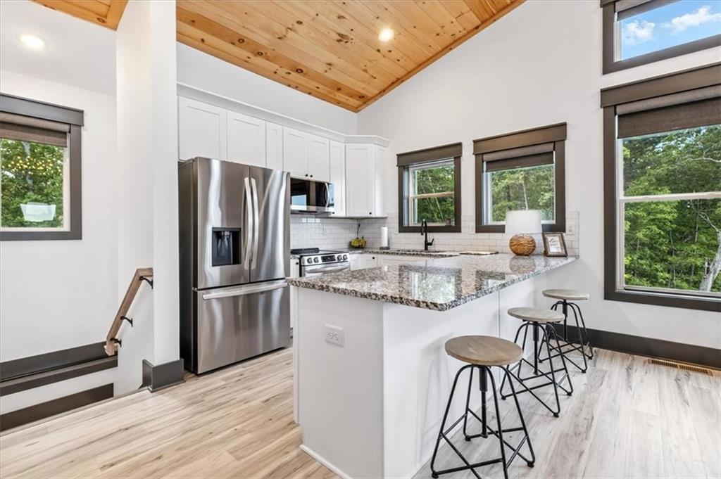 1379 Foxhound Trail Northeast Ranger, GA 30734 - Photo 14 of 42 a kitchen with stainless steel appliances granite countertop a stove a refrigerator a kitchen island and chairs in it