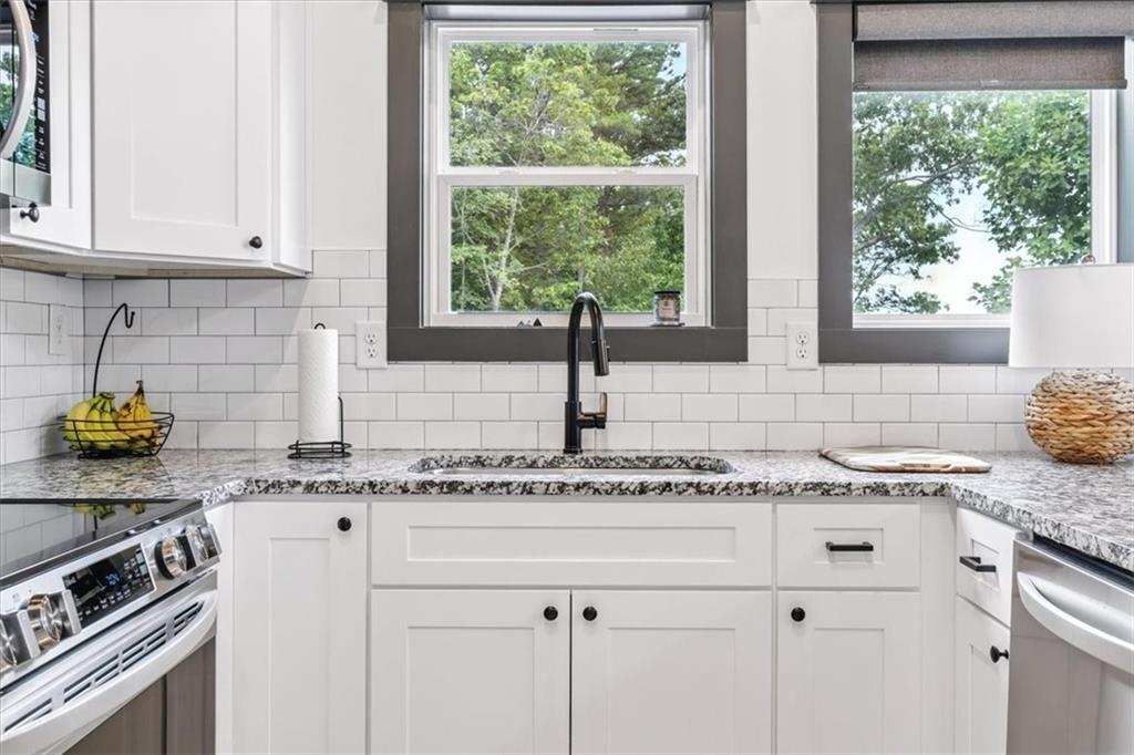 1379 Foxhound Trail Northeast Ranger, GA 30734 - Photo 15 of 42 a kitchen with stainless steel appliances granite countertop a sink a stove cabinets and a window