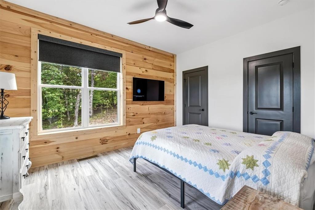 1379 Foxhound Trail Northeast Ranger, GA 30734 - Photo 20 of 42 a bedroom with a bed and a large window with wooden floor