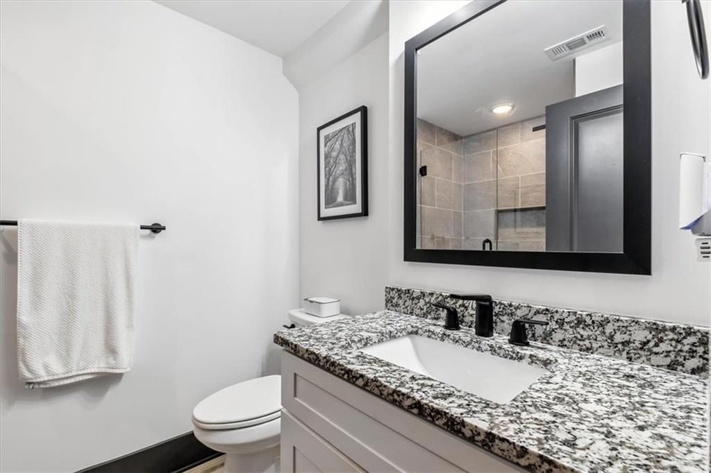1379 Foxhound Trail Northeast Ranger, GA 30734 - Photo 33 of 42 a bathroom with a granite countertop sink mirror vanity and toilet