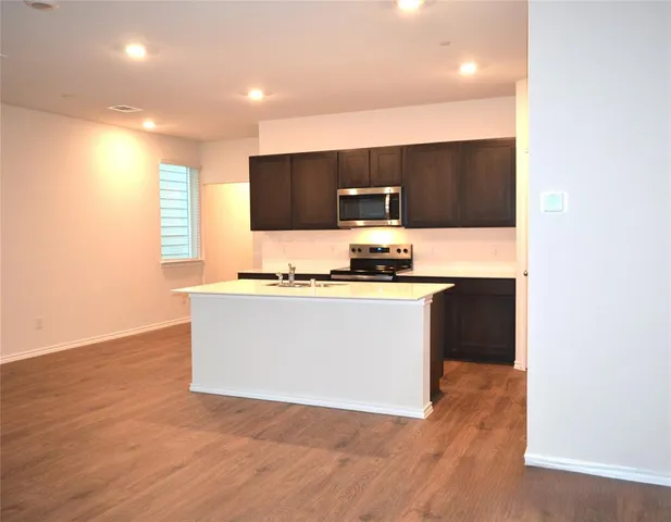a view of kitchen with stainless steel appliances cabinets and wooden floor