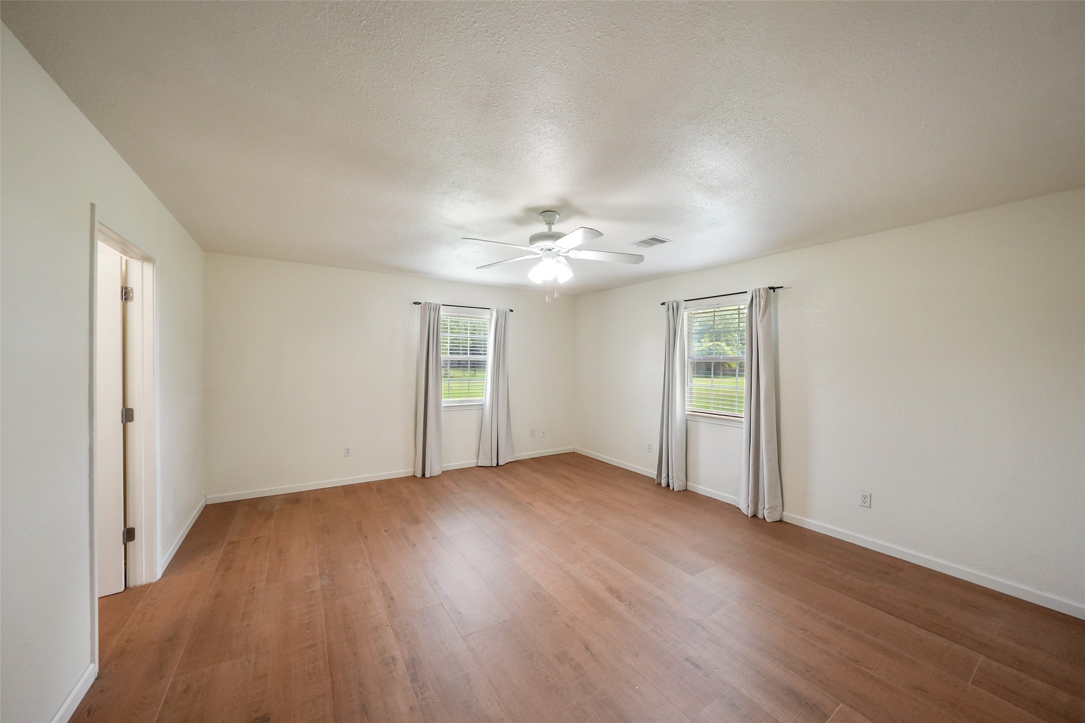 19635 Kermier Road Waller, TX 77484 - Photo 17 of 27 Spacious primary bedroom with dual closets and plenty of room for a sitting area or additional furnishings.