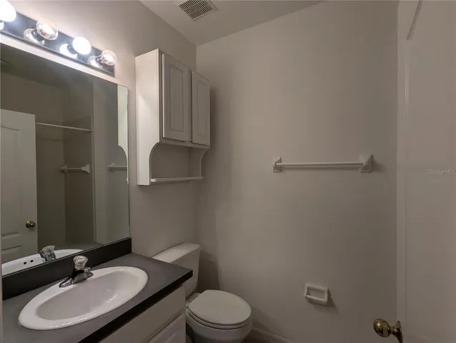 a bathroom with a sink toilet and a mirror