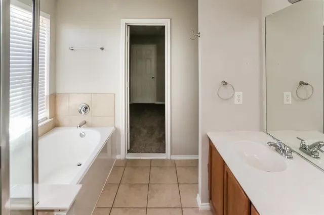 a spacious bathroom with a bathtub sink and mirror