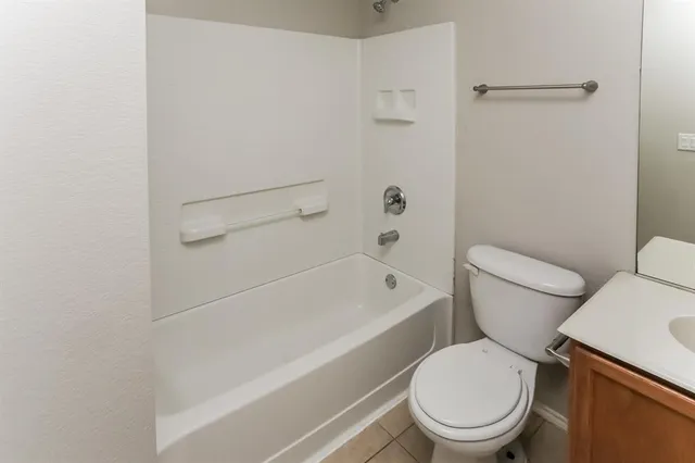 a white toilet and tub next to a white cabinet