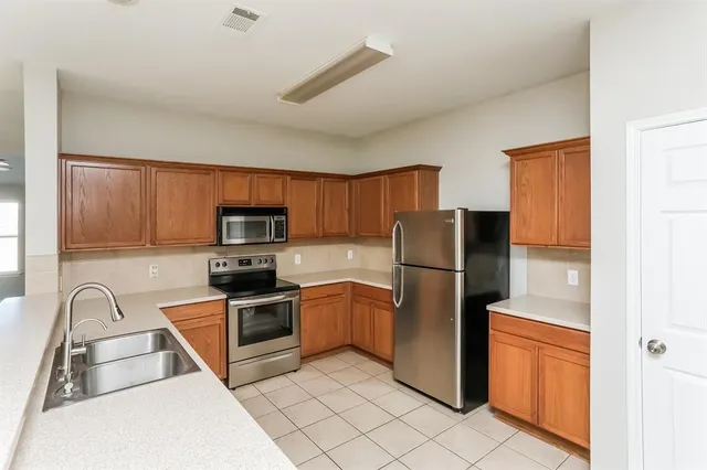 a kitchen with stainless steel appliances granite countertop a refrigerator stove and sink