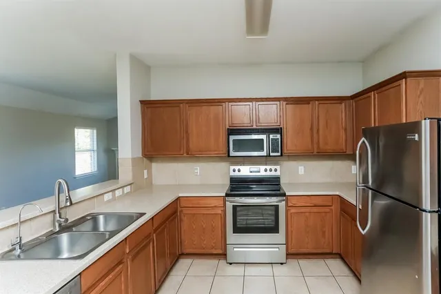 a kitchen with a refrigerator sink and microwave