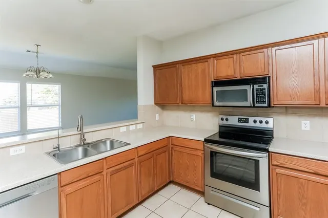 a kitchen with stainless steel appliances granite countertop a sink stove and microwave