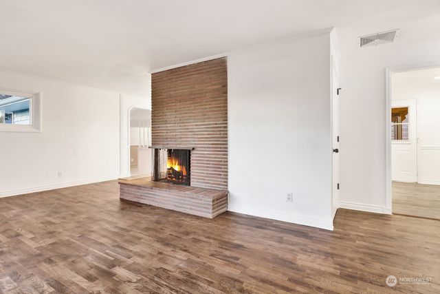 a view of a livingroom with wooden floor and a fireplace