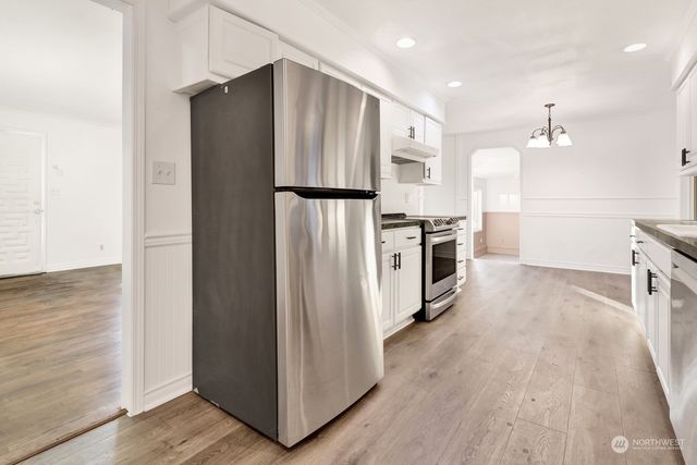 a kitchen with stainless steel appliances a refrigerator and a stove top oven