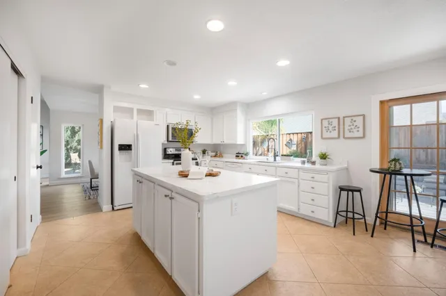 a kitchen with white cabinets sink and appliances