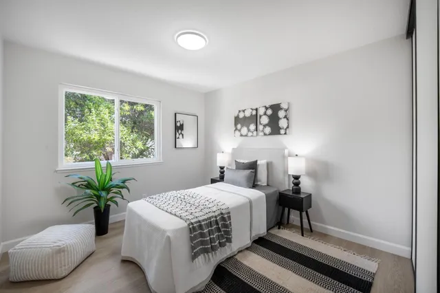 a bedroom with a bed and a potted plant