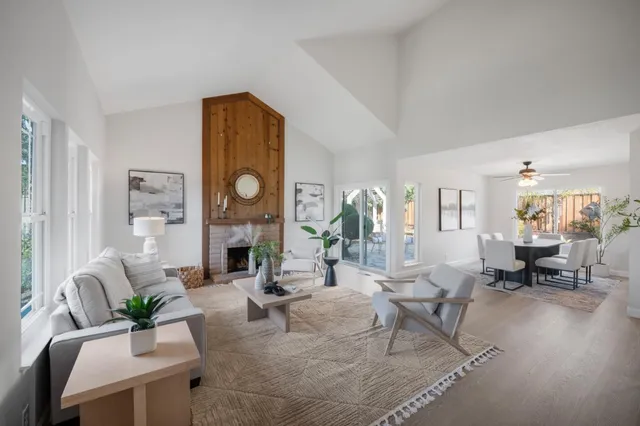 a living room with fireplace furniture and a large window