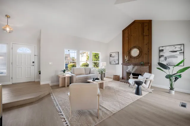 a living room with fireplace furniture and a large window