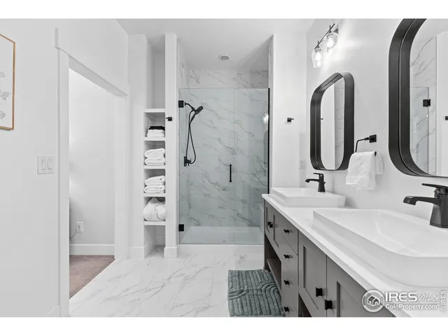 a bathroom with a double vanity sink mirror and shower